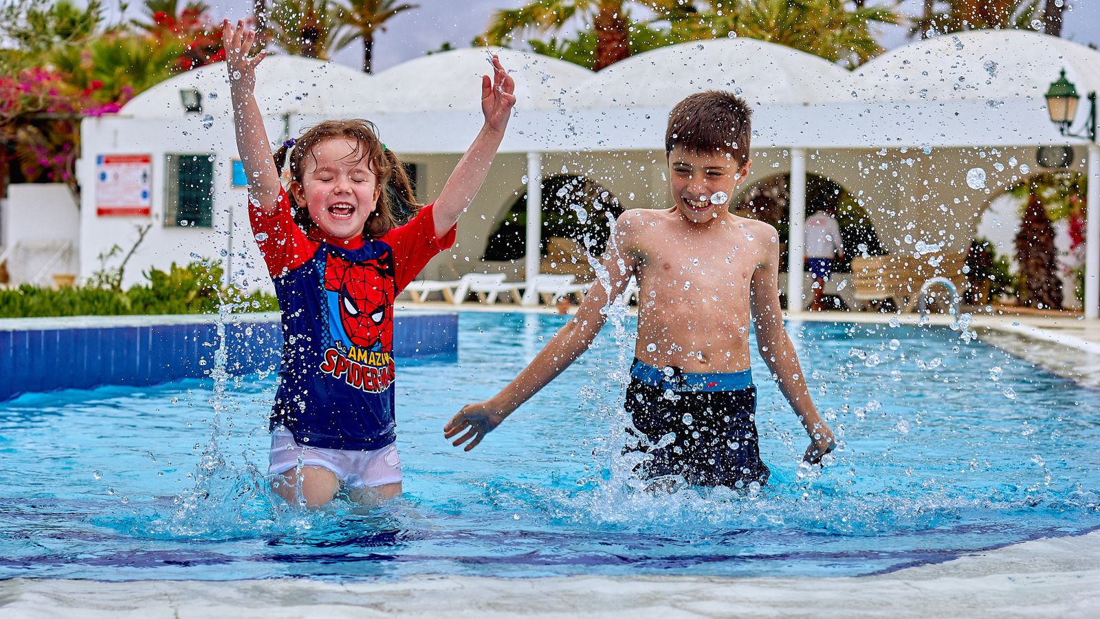 Enfants s'amusant dans la piscine d'un village vacances en été